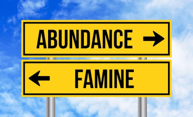 Abundance or famine road sign on blue sky background