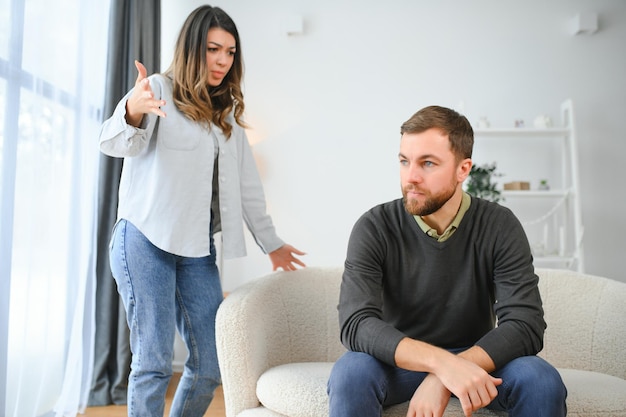 Photo abusive wife arguing husband jealous distrustful dominant woman shouting at sad man