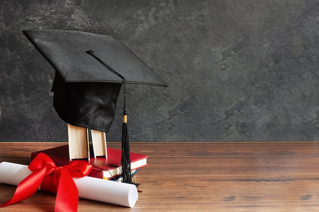 Academic cap and graduation diploma scroll and tied with red ribbon