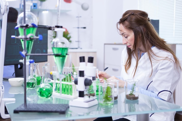 Academic female scientist in a microbiology laboratory. Microscope in lab research.