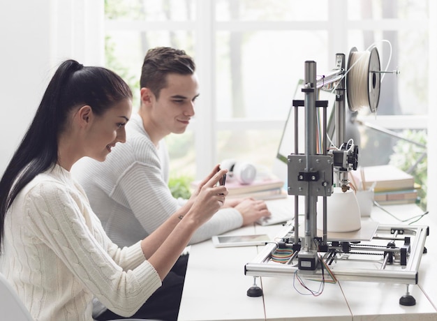 Academic students using a 3D printer in the lab