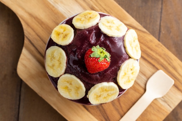 Acai, 브라질 냉동 Acai 베리 아이스크림 그릇. 나무 테이블에 과일. 여름 메뉴 평면도