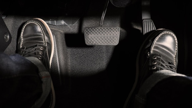 Accelerator and breaking pedal in a car. Close up the foot pressing foot pedal of a car to drive ahead. Driver driving the car by pushing accelerator pedals of the car. Foot pedals inside vehicle.