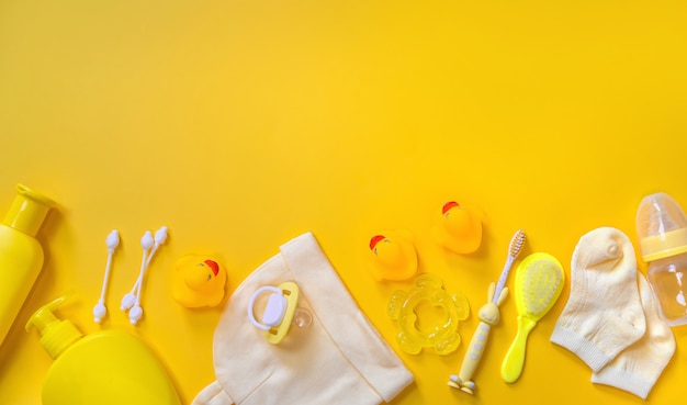Accessoires voor het baden van pasgeborenen op een geel.