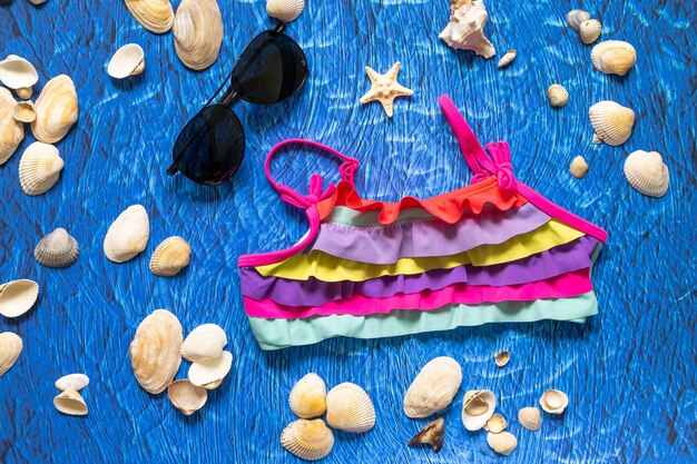 accessoires voor zomer zee strand op blauwe wawes achtergrond. Zonnebrillen en zwemkleding voor stranddingen