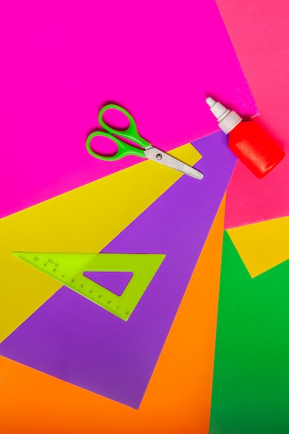 Photo accessories for applique. scissors, glue, colored paper and a ruler. top view.