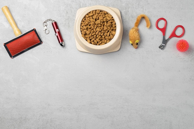 Accessories for cats: comb, ball, nail clippers, mouse. The concept of pet care. Gray background, copy space