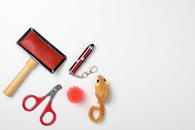 Accessories for cats: comb, ball, nail clippers, mouse. The concept of pet care. White background, copy space
