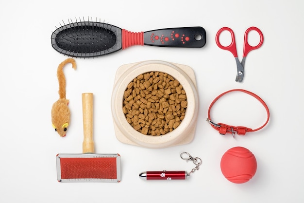 Accessories for cats: comb, ball, nail clippers, mouse. The concept of pet care. White background, top view