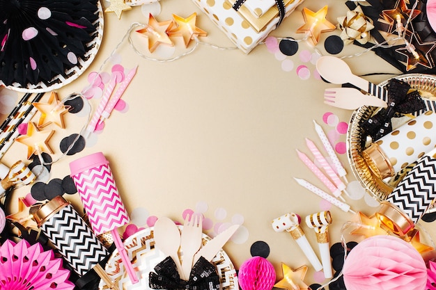 Accessories for children's parties. Gold, black and pink color. Flat lay, top view