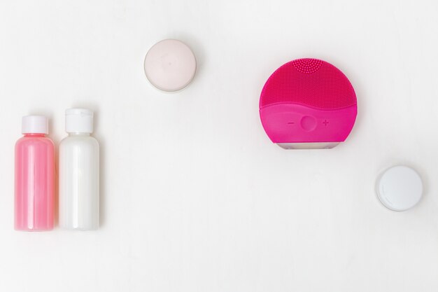 Accessories for cleansing skin, electric brush, moisturizer, cleanser. Beauty and skincare concept. Flat lay. Top View.