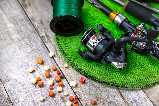 Accessori per la pesca su uno sfondo di legno. messa a fuoco selettiva. pesca.