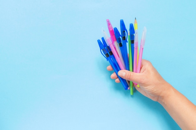 Foto accessori per la scuola, quaderni, penne, matite per il posto di lavoro di uno scolaro su sfondo blu
