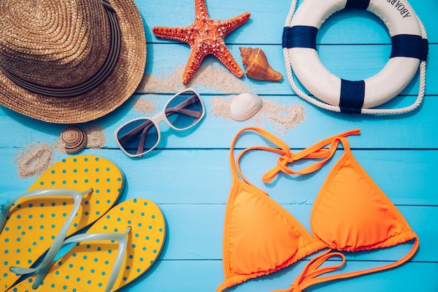 Accessories with woman for travel summer. On blue wooden floor