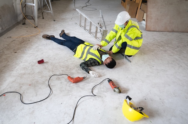 Foto un incidente di un lavoratore uomo in cantiere. l'assiste ai feriti delle primarie. focus di selezione su una persona ferita.