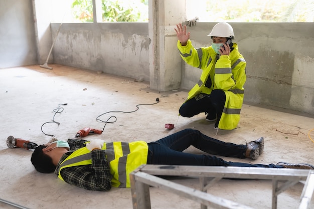 Incidente di un operaio in cantiere e chiamata all'addetto alla sicurezza per il soccorso e il salvataggio. focus di selezione su una persona ferita.