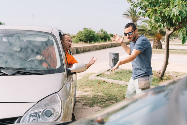 Accident between two cars with two people outdoors