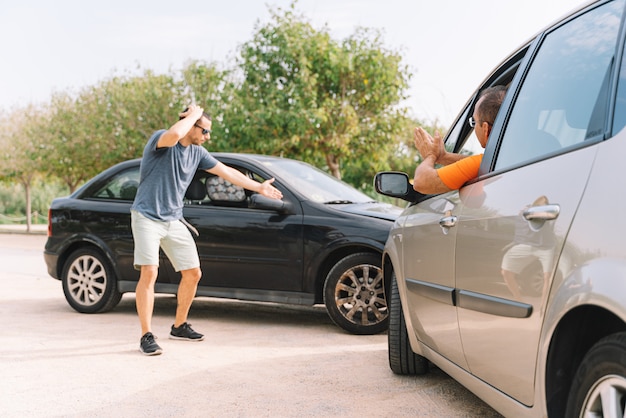 Accident between two cars with two people outdoors