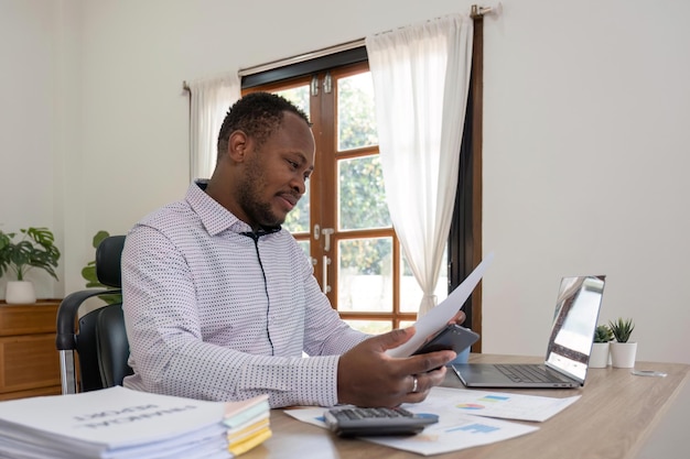 Accountant black man working on laptop and do document tax exchange accounting and Financial advisor concept