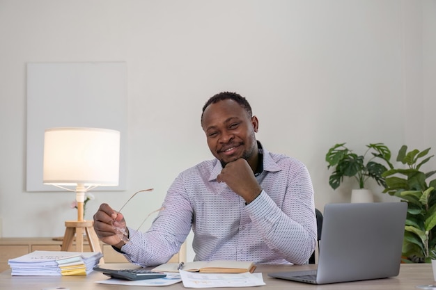 Accountant black man working on laptop and do document tax exchange accounting and Financial advisor concept