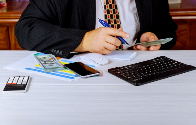 Accountant businessman counting money making notes at report doing finance