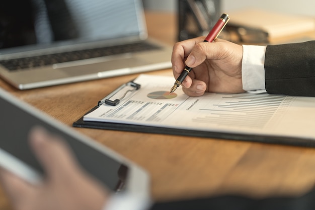 The accountant checking documents about graph and chart relating to financial reporting and tax accounting of the company