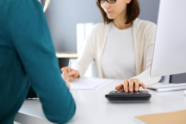 Accountant checking financial statement or counting by\
calculator income for tax form hands closeup