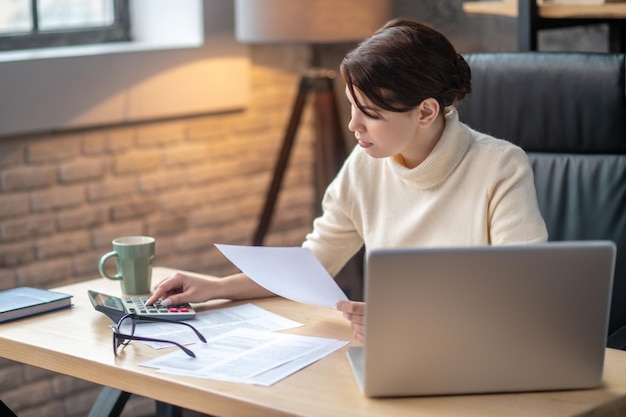 Accountant die financiële berekeningen maakt aan de schrijftafel