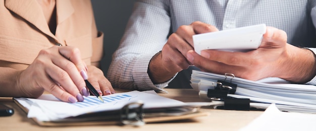 Accountant die financiële verklaring controleert of door rekenmachineinkomsten voor belastingformulier telt