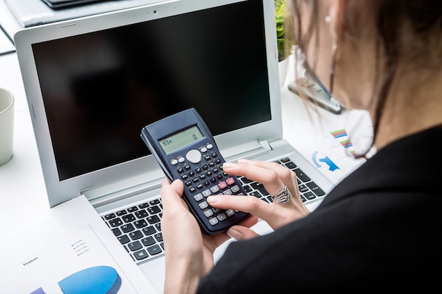 Accountant die met calculator werkt