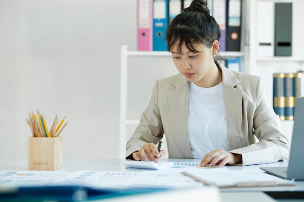 写真 会計士は、電卓を使用して机の上で作業しています