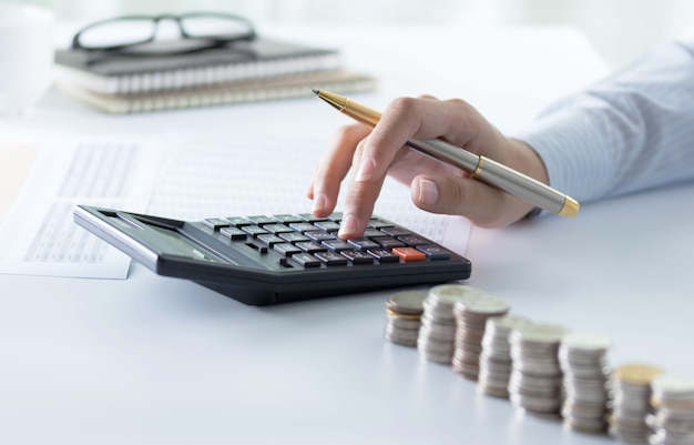 Accountant using calculator for checking numbers from balance sheet and financial statemen