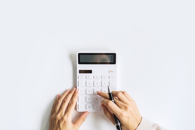 Accountant using calculator on desk office on white background with copy space, Top view