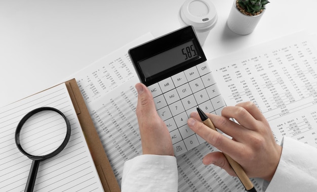 Accountant using calculator on desk office on white background with financial statement Top view