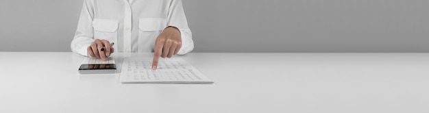 Accountant using a calculator and points her finger at the numbers in the financial statement