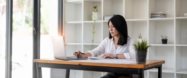 Accountant woman using laptop computer and calculator for business finance paperwork