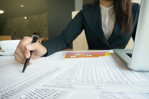 Accountant Working women uses calculator with Spreadsheet document, information financial concept.