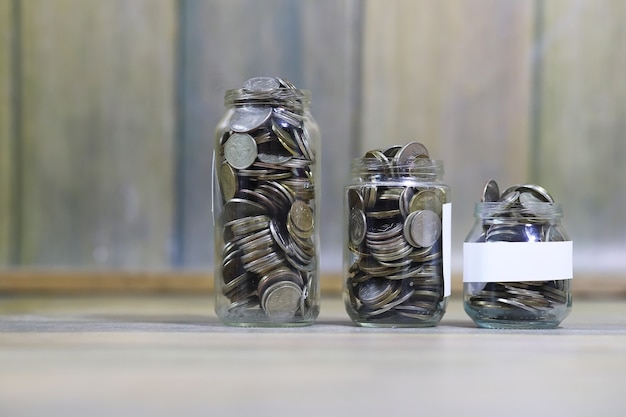 Accumulated coins stacked in glass jars on the floor