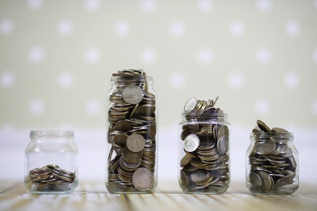 Accumulated coins stacked in glass jars on the floor