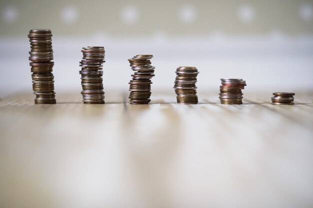 Accumulated coins stacked in piles on the wooden floor