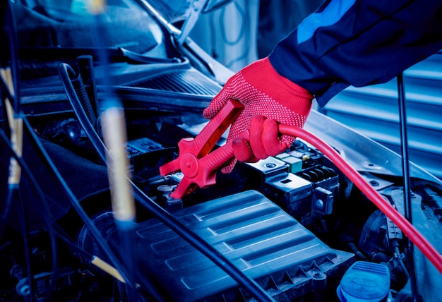 Accumulator charging. Hands and terminals. Car repair.