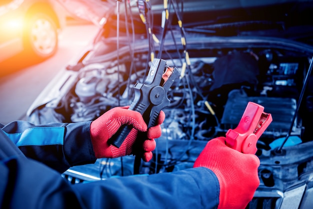 Accumulator charging. Hands and terminals. Car repair.