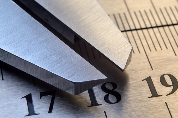 Photo accurate measuring tool caliper and metal ruler lie on top of each other closeup