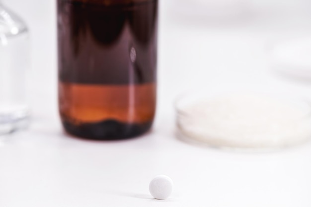 Photo acetylsalicylic acid tablet with salicylic acid and acetic anhydride in the background