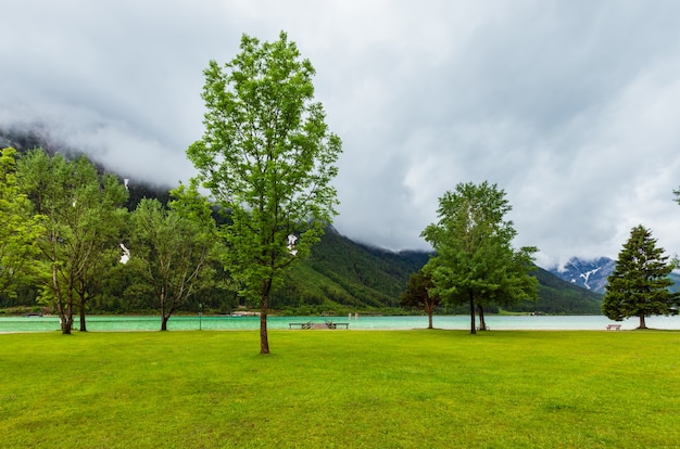 Achensee (Achenmeer) zomerlandschap met groene weide en houten ligplaats (Oostenrijk).