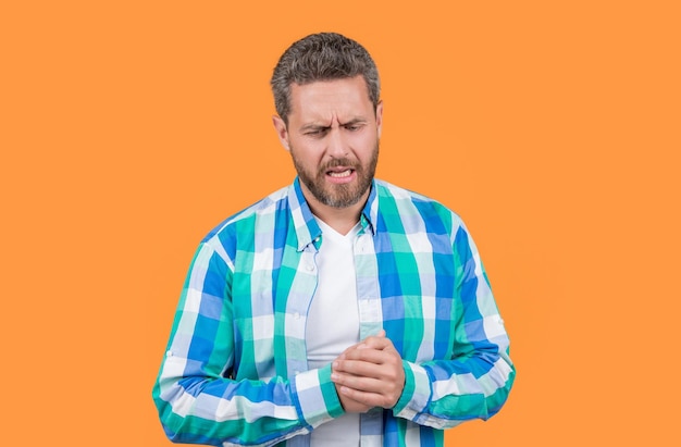 Photo aching feeling caucasian man has ache in hand isolated on yellow background man with ache