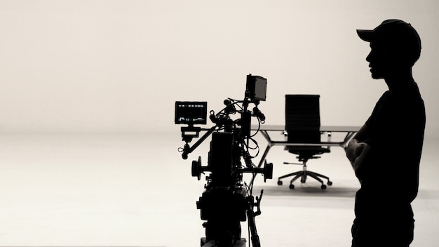 Foto achter de schermen of making of film in de studio en silhouet van cameraman.