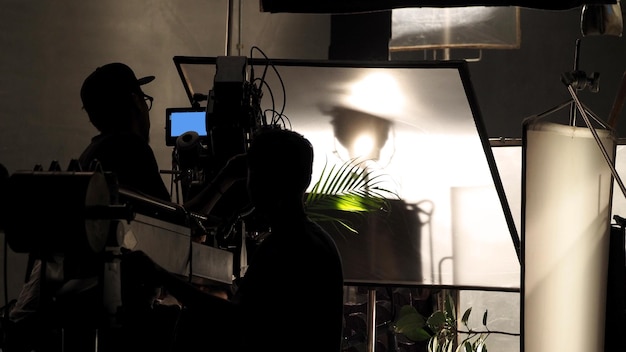 Foto achter de schermen van het filmen van videocommercials in de grote studio en het productieteam werken