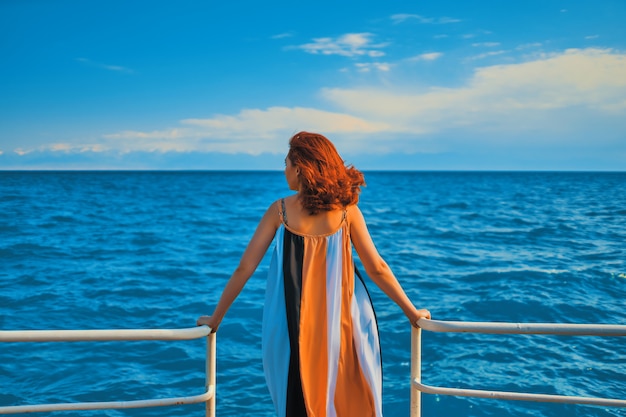 Achter meisje op pier. Vrouw in kleurrijke kleding die zich op de pijler bevindt.