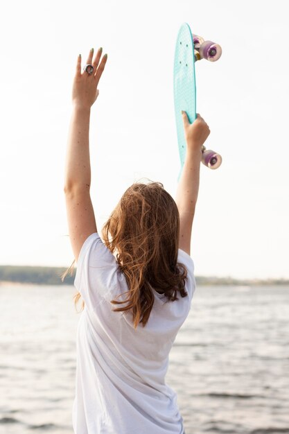 Achter mening van vrouw door het skateboard van de meerholding